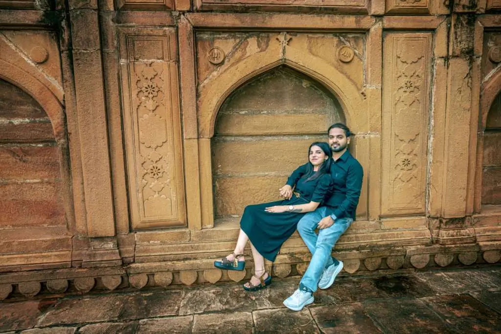 Romantic couple portrait sitting beside vintage heritage wall during pre wedding shoot