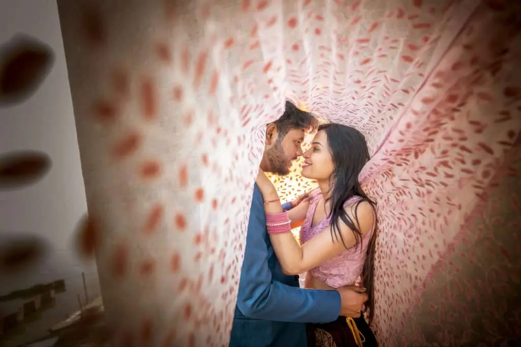 Romantic pre wedding closeup pose of couple under transparent dupatta fabric