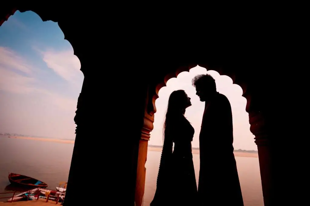 Romantic silhouette pre wedding portrait of couple under traditional archway